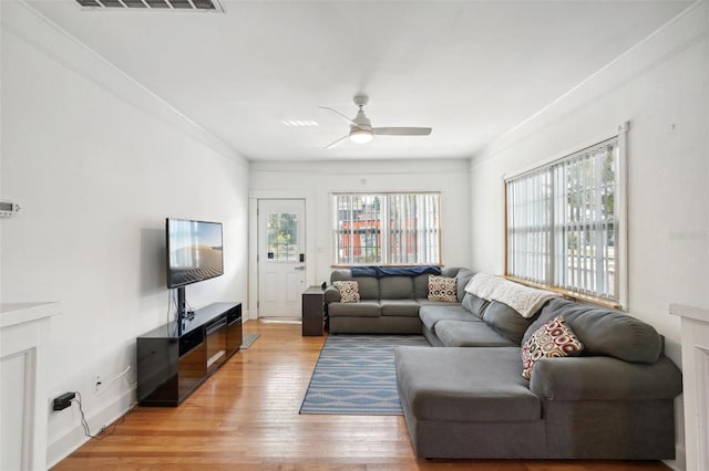 living room featuring ceiling fan, a healthy amount of sunlight, light hardwood / wood-style floors, and crown molding