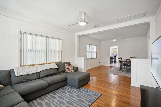 living room featuring ceiling fan, ornamental molding, and hardwood / wood-style flooring