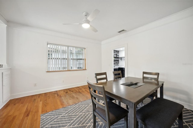 dining area with hardwood / wood-style flooring, ceiling fan, and ornamental molding