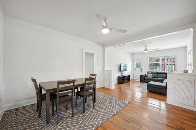 dining space featuring hardwood / wood-style floors, ceiling fan, and crown molding