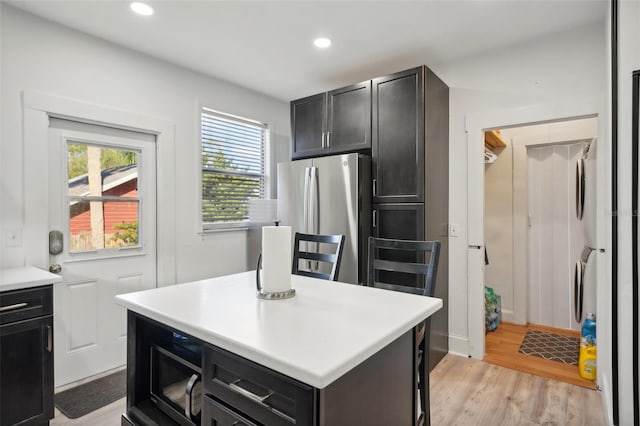 kitchen with a center island, stainless steel fridge, and light hardwood / wood-style floors