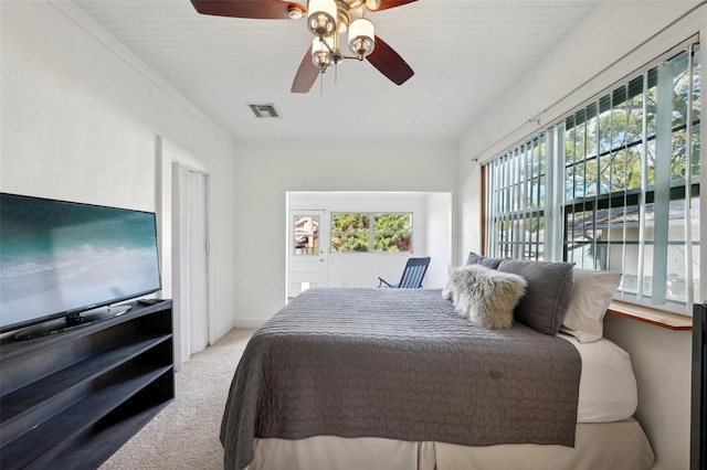 carpeted bedroom with ceiling fan, crown molding, and multiple windows