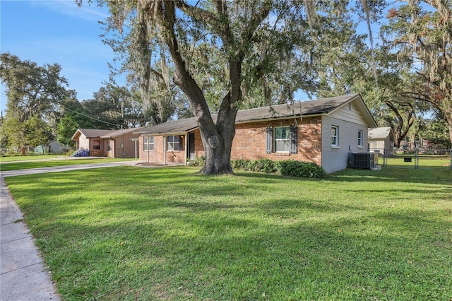 ranch-style house featuring central air condition unit and a front yard