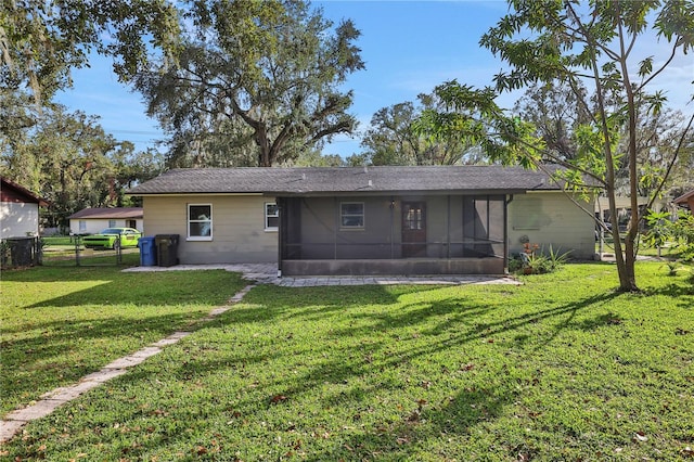 back of house featuring a yard and a sunroom