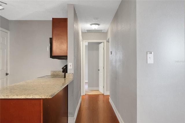 hallway featuring sink and hardwood / wood-style floors