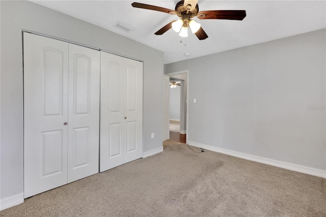 unfurnished bedroom with light carpet, a closet, and ceiling fan