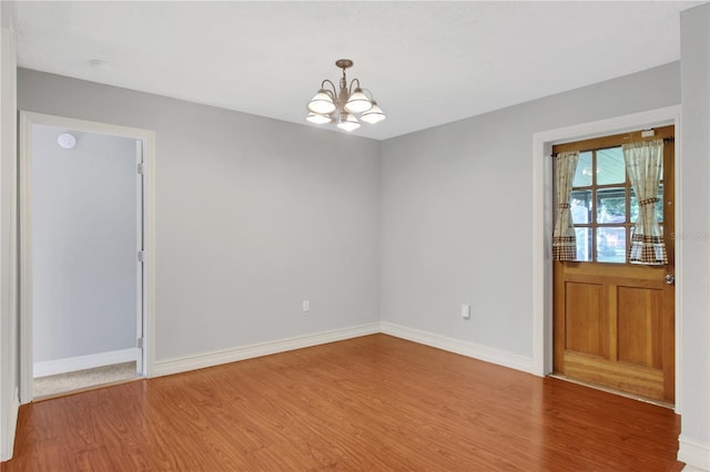 empty room featuring hardwood / wood-style floors and a notable chandelier