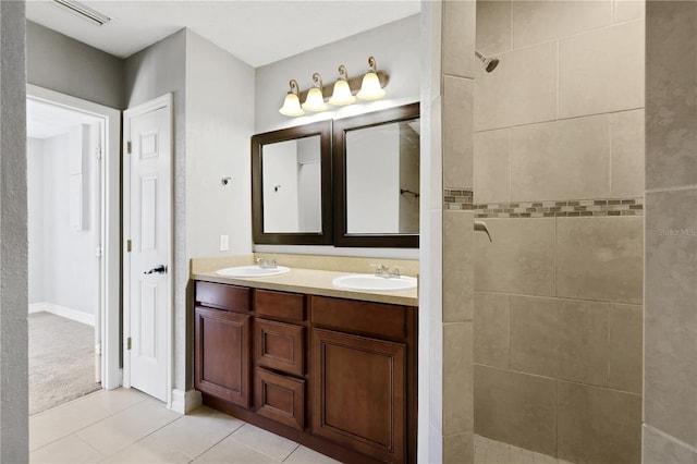 bathroom featuring vanity, tile patterned floors, and tiled shower