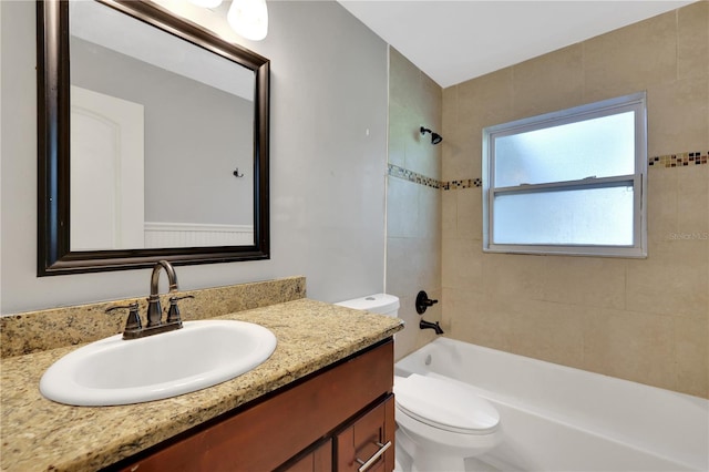 full bathroom with tiled shower / bath combo, toilet, and vanity