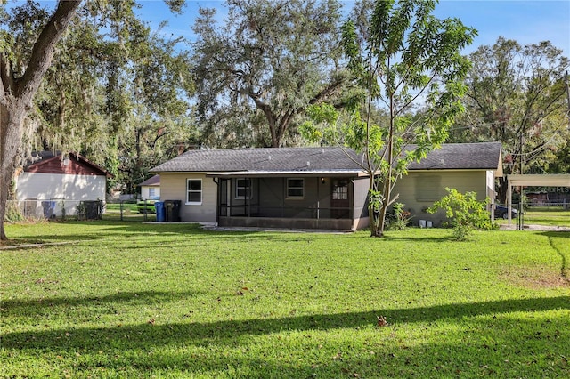 back of property featuring a yard and a sunroom