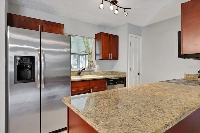 kitchen featuring a textured ceiling, appliances with stainless steel finishes, track lighting, sink, and light stone counters