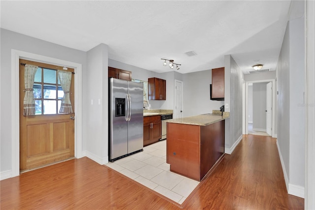 kitchen featuring light hardwood / wood-style floors, kitchen peninsula, and appliances with stainless steel finishes