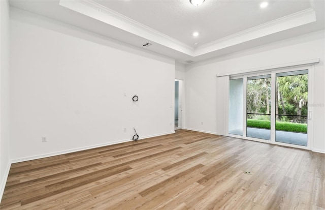 spare room with baseboards, a raised ceiling, ornamental molding, light wood-style floors, and recessed lighting