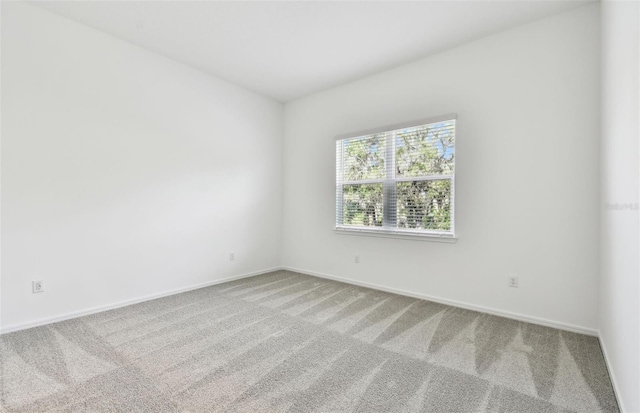 carpeted spare room featuring baseboards