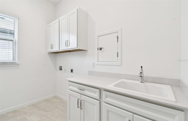 laundry area with hookup for an electric dryer, washer hookup, a sink, baseboards, and cabinet space