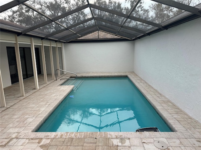 view of pool with a patio area and a lanai