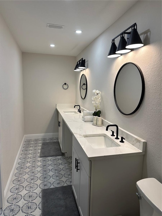 bathroom with tile patterned flooring, vanity, and toilet