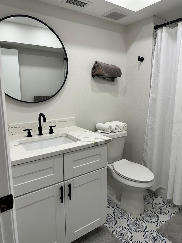 bathroom featuring tile patterned flooring, a shower with curtain, vanity, and toilet