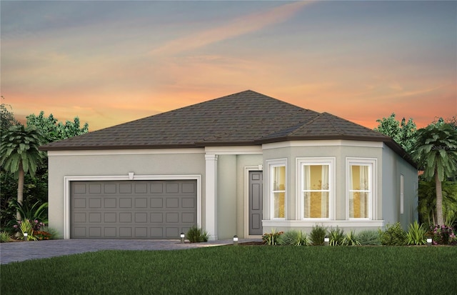 view of front of home with a lawn and a garage