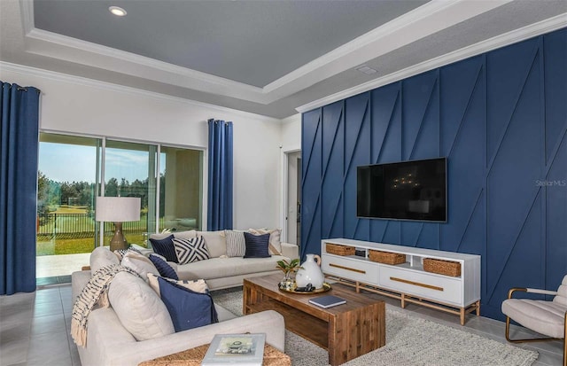 living room featuring ornamental molding, tile patterned floors, a raised ceiling, and a healthy amount of sunlight