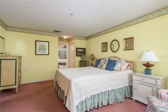 carpeted bedroom featuring a textured ceiling and ensuite bath