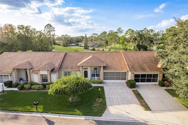 ranch-style home featuring a garage and a front lawn