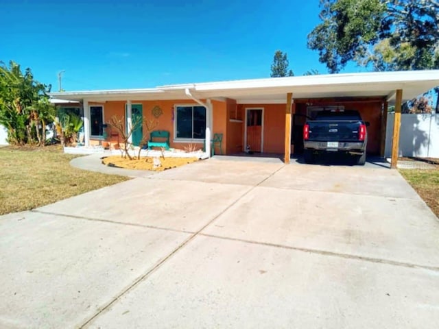 ranch-style house featuring a carport and a front yard