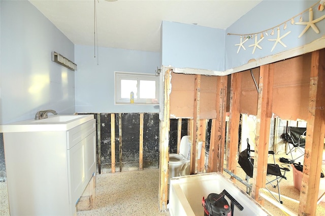 bathroom with a sink and speckled floor