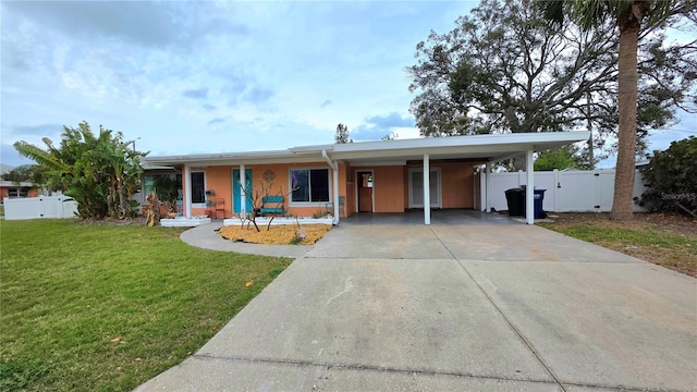 ranch-style home featuring an attached carport, fence, concrete driveway, a gate, and a front lawn