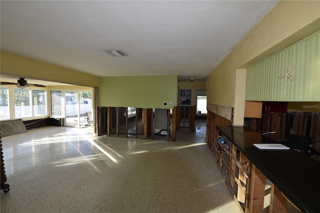 interior space with visible vents, a wealth of natural light, and speckled floor