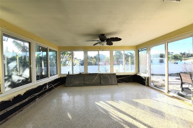 unfurnished sunroom featuring ceiling fan