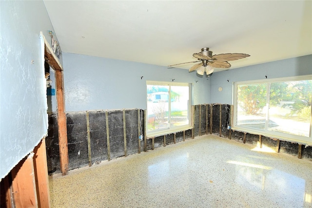 empty room featuring ceiling fan and speckled floor