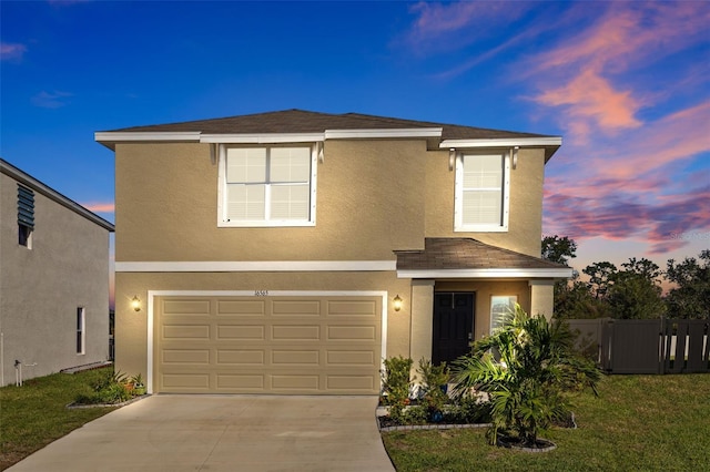 view of front of house with a garage and a yard