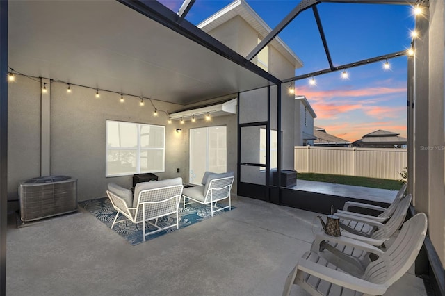 patio terrace at dusk with a lanai and central AC unit