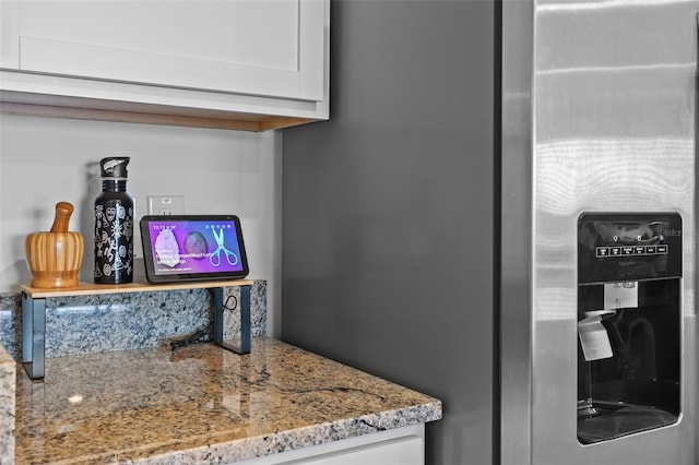 details featuring white cabinetry and light stone counters