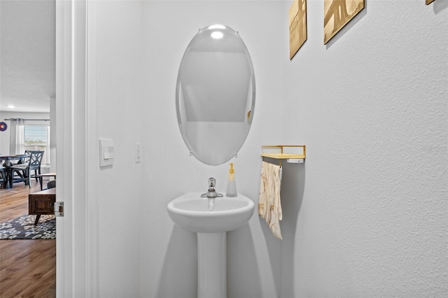 bathroom featuring hardwood / wood-style floors and a textured ceiling