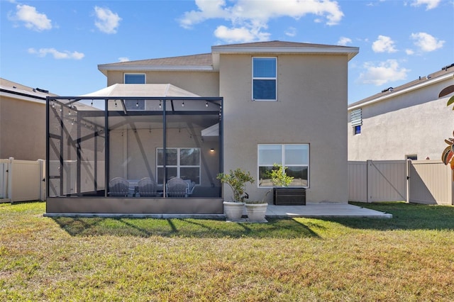 back of house featuring a patio, a lanai, and a lawn