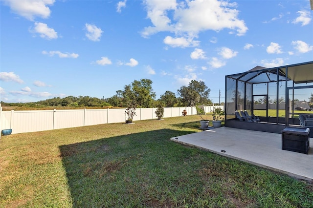 view of yard featuring glass enclosure and a patio