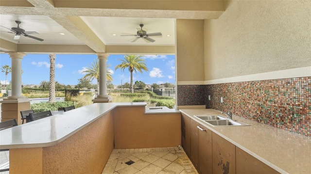 view of patio / terrace with ceiling fan, exterior kitchen, and sink