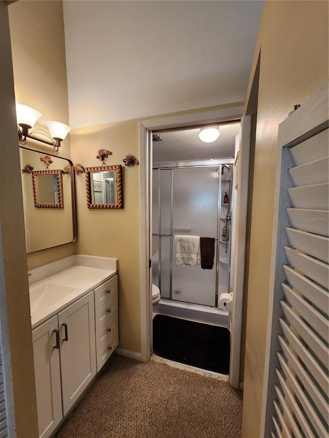 bathroom with toilet, vanity, and walk in shower