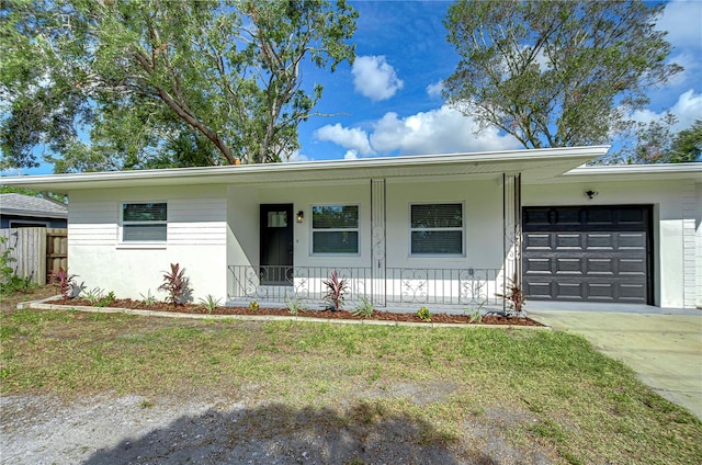 single story home featuring a front lawn, covered porch, and a garage