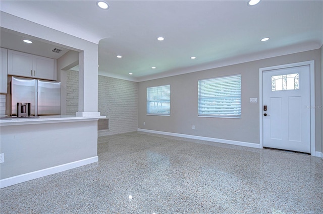 unfurnished living room with brick wall