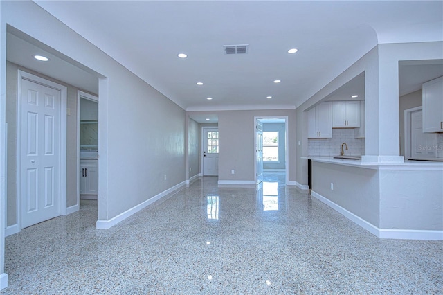 kitchen featuring backsplash, white cabinetry, and sink