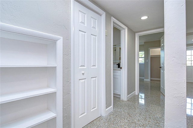 hallway with a textured ceiling and a wealth of natural light