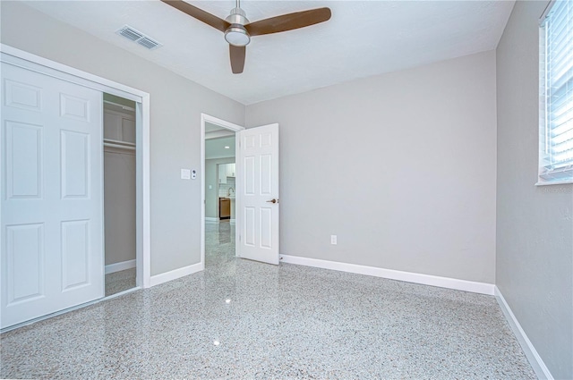 unfurnished bedroom with ceiling fan and a closet