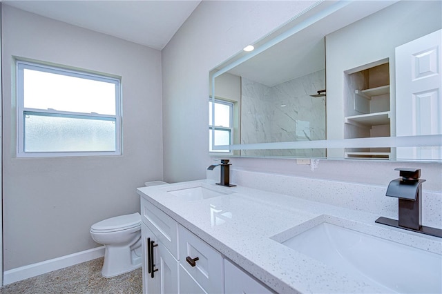 bathroom featuring vanity, toilet, and tiled shower