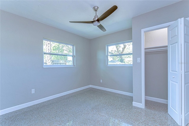 unfurnished bedroom with ceiling fan and a closet