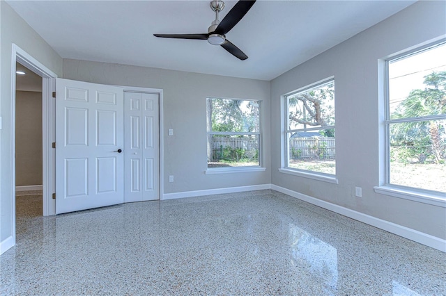 unfurnished bedroom featuring a closet, multiple windows, and ceiling fan