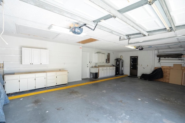 garage featuring a garage door opener, electric water heater, and sink