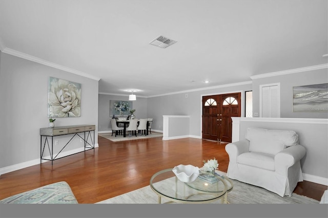 living room with wood-type flooring and crown molding